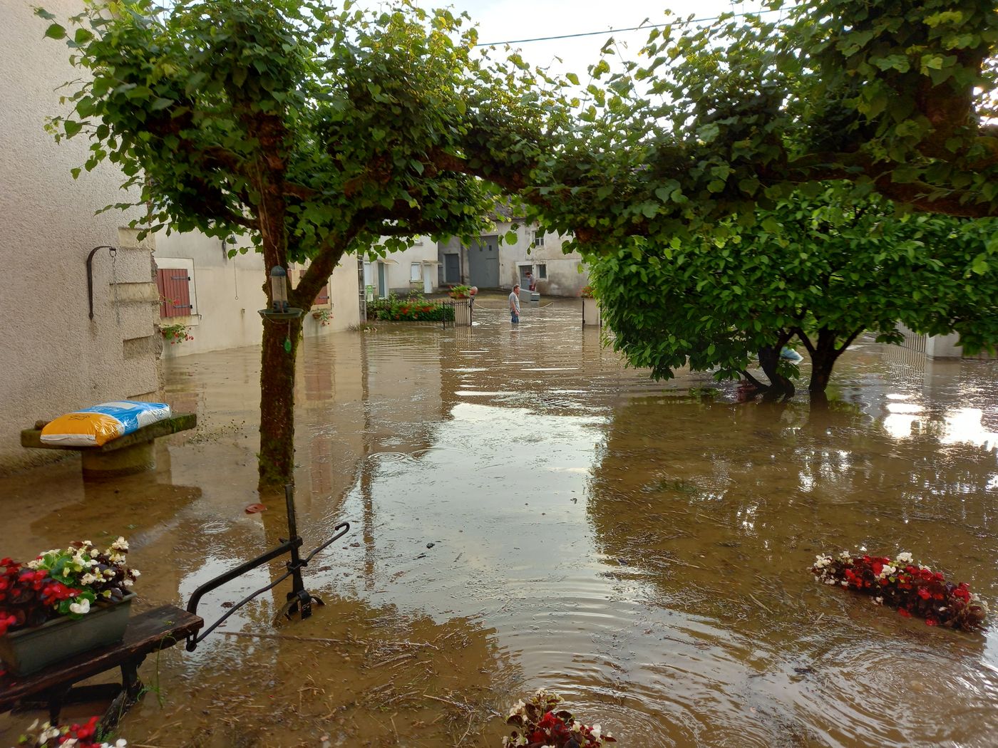 Cour et rue de village envahies par l'eau après le débordement d'un cours d'eau