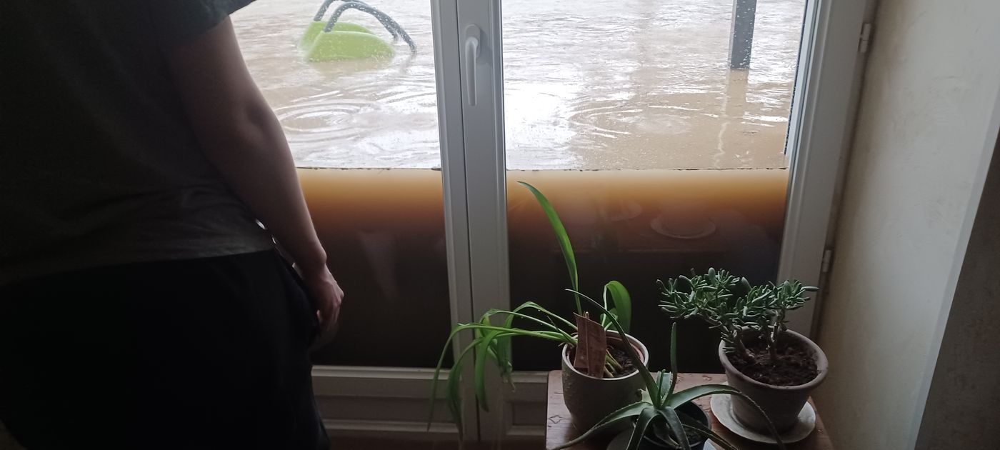 Vue depuis l'intérieur : l'eau affleure le seuil de la baie vitrée